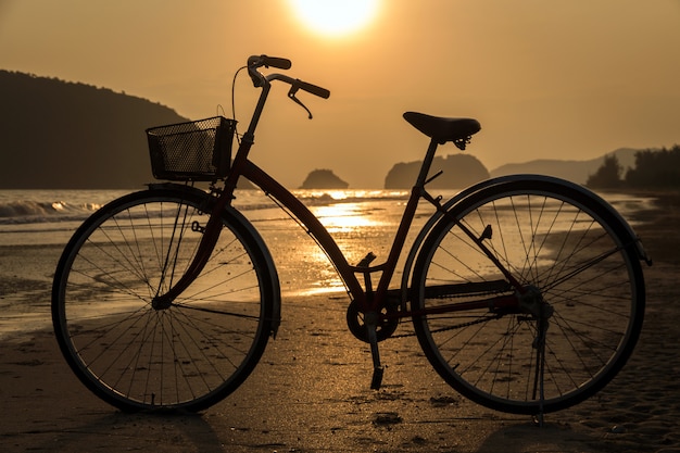 Silhouette des Fahrrads am Strand, Fahrräder am Strand Sonnenuntergang oder Sonnenaufgang