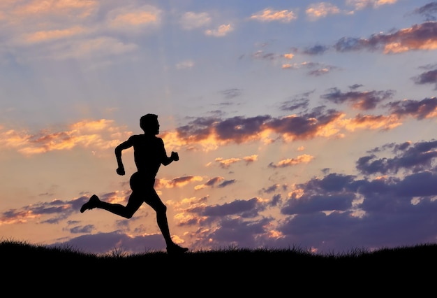 Silhouette des Mannläufers bei Sonnenuntergang. Das Konzept von Sport und Erholung