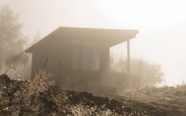 Silhouette des modernen schwarzen Hauses am nebligen Morgen