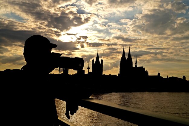 Foto silhouette einer brücke über einen fluss gegen einen bewölkten himmel