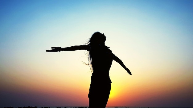 Silhouette einer Frau beim Sonnenuntergang