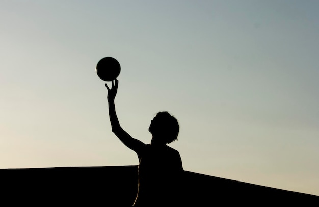 Silhouette einer Frau und eines Balls in der goldenen Stunde Dunkelheit und Licht Person