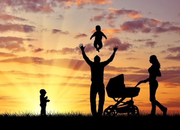 Silhouette einer glücklichen Familie mit Kindern auf dem Hintergrund eines Sonnenuntergangs