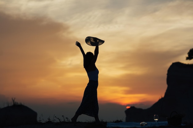 Foto silhouette einer jungen frau mit erhobenen händen