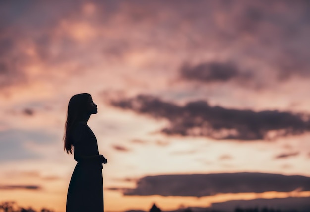 Silhouette einer schönen jungen Frau mit langen Haaren beim Sonnenuntergang