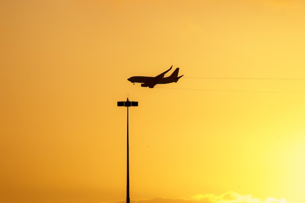 Silhouette eines Flugzeugs mit einem schönen orangefarbenen Himmel in Rio de Janeiro Brasilien