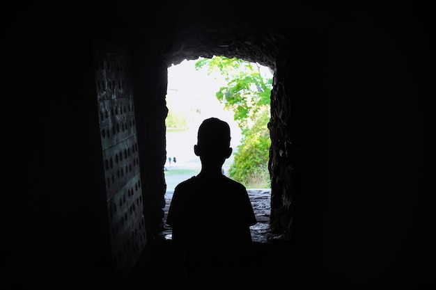 Silhouette eines Jungen im Fenster des Forts, Blick aus der Dunkelheit