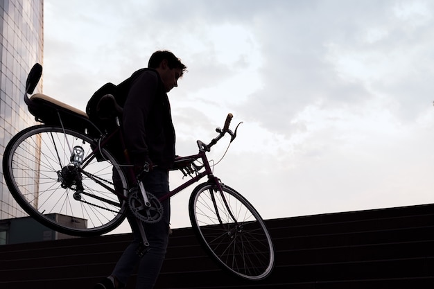 Silhouette eines jungen Mannes mit Fahrrad