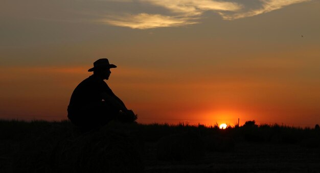 Foto silhouette eines mannes auf dem feld gegen den himmel bei sonnenuntergang