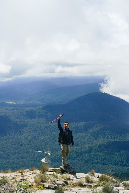 Silhouette eines Mannes auf einem Gipfel mit erhobenen Armen auf dem höchsten Berg