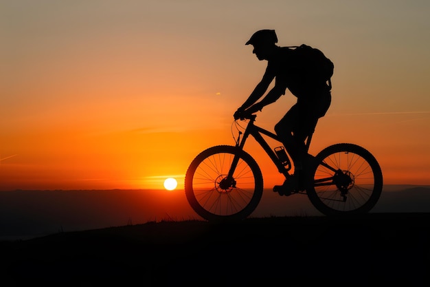 Silhouette eines Mannes auf einem Mountainbike bei Sonnenuntergang