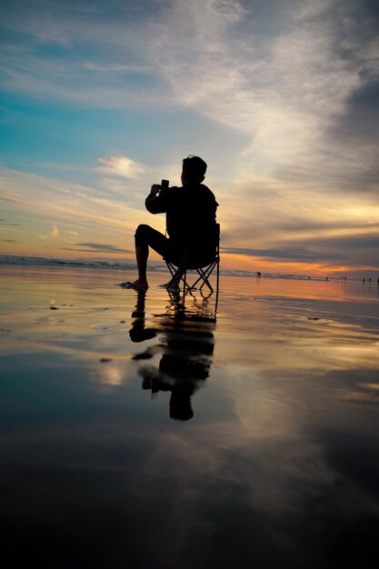 Foto silhouette eines mannes, der den klaren nachmittagshimmel genießt