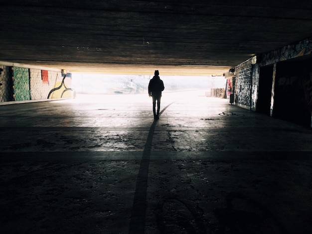 Foto silhouette eines mannes, der im tunnel geht