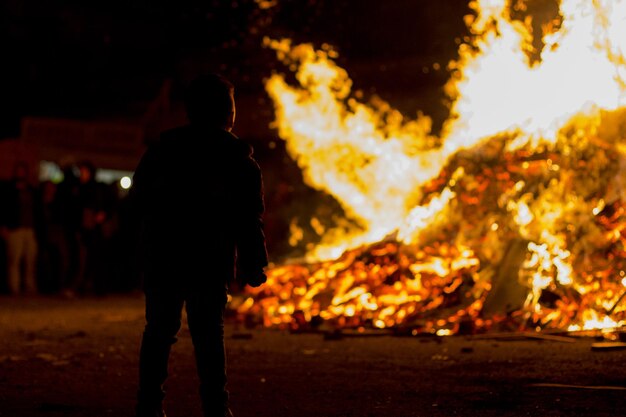 Foto silhouette eines mannes, der nachts am lagerfeuer steht