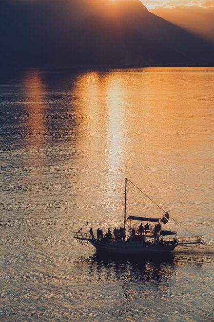 Silhouette eines Mannes im Boot im Meer bei Sonnenuntergang