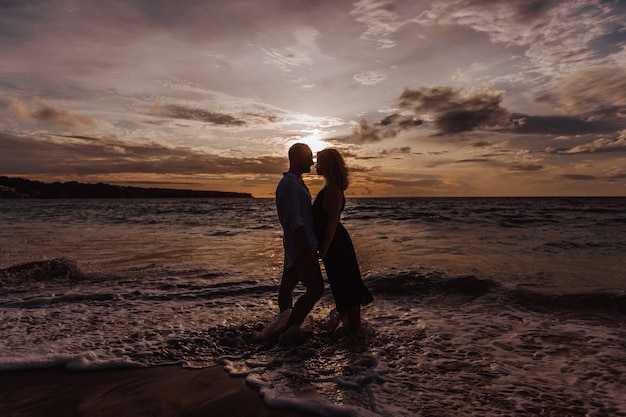 Silhouette eines Mannes und einer Frau gegen die Wand des Sonnenuntergangs