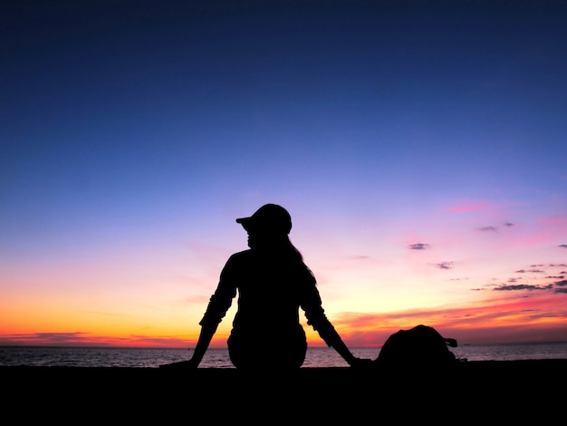Silhouette Frau sitzen auf See, Sonnenuntergang Licht
