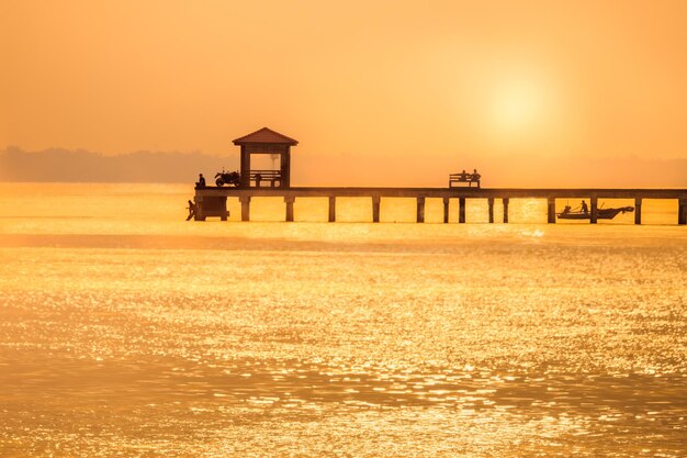 Silhouette gebaute Struktur auf dem Meer gegen den Himmel bei Sonnenuntergang