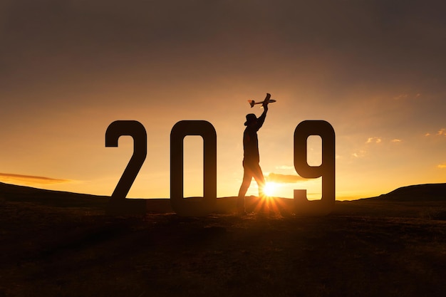 Foto silhouette-hiker mit zahlen, die während des sonnenuntergangs auf dem feld gegen den himmel stehen