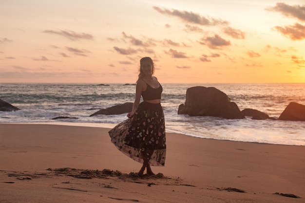 Silhouette junge Frau entspannt am Meeresstrand bei Sonnenuntergang Hintergrund Dame am Meeresstrand in den Sommerferien