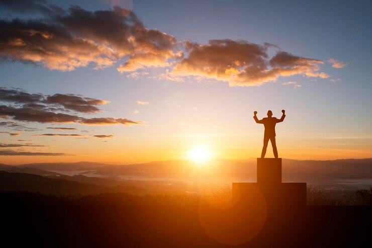 Foto silhouette-junge steht bei sonnenuntergang auf dem podium gegen den himmel