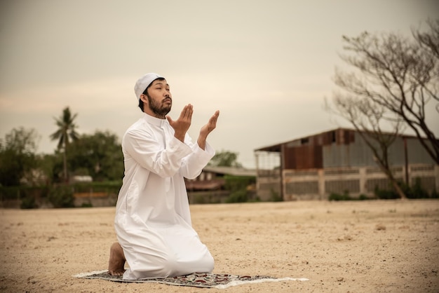 Silhouette Junger asiatischer muslimischer Mann, der auf dem Konzept des SunsetRamadan-Festivals betet