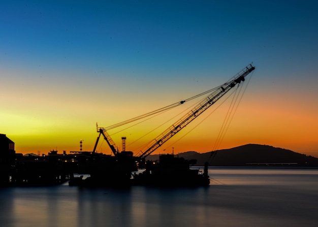 Silhouette-Kran am kommerziellen Dock vor klarem Himmel