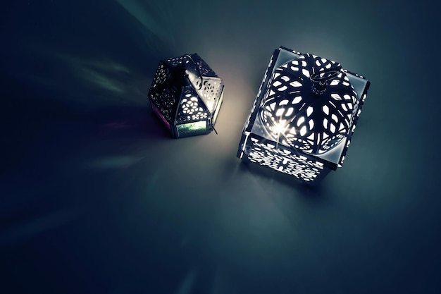 Silhouette leuchtender marokkanischer Zierlaternen in der Nacht mit dekorativen Schatten Grußkarteneinladung für den muslimischen heiligen Monat Ramadan Kareem Festlicher Hintergrund Flache Draufsicht Iftar-Tisch