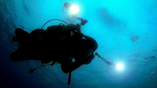 Foto silhouette mann tauchen im meer