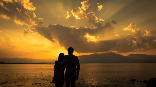 Silhouette-Paar steht bei Sonnenuntergang am Strand