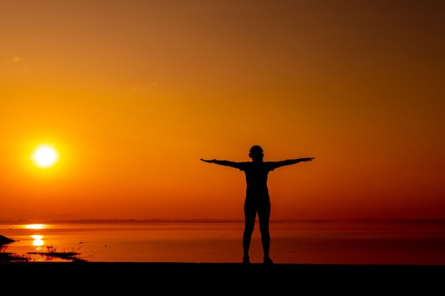 Silhouette sportliche Frau mit Sonnenuntergang. Gesunde und sportliche Aktivität. Lebensstil und Erholung.