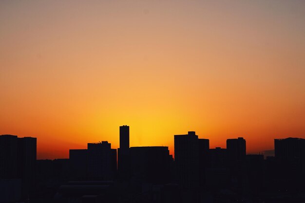 Foto silhouette stadtlandschaft gegen orangefarbenen himmel