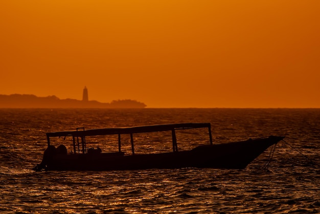 Silhouette von Fischerbooten, die bei Sonnenuntergang im Indischen Ozean Sansibar verankert sind