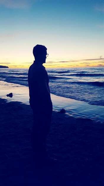 Foto silhouette von männern, die am strand stehen