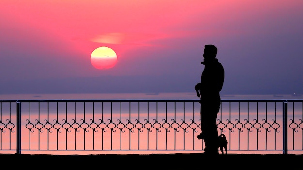 Silhouette von Menschen am Meer bei Sonnenuntergang