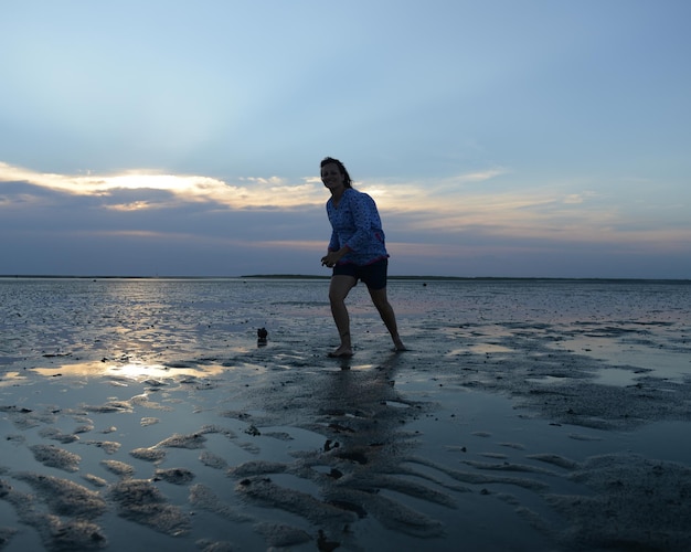 Silhouette von Menschen am Strand bei Sonnenuntergang