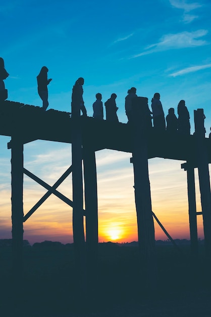 Silhouette von Menschen auf einer Brücke gegen den Himmel bei Sonnenuntergang