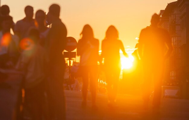 Foto silhouette von menschen, die bei sonnenuntergang in der stadt stehen