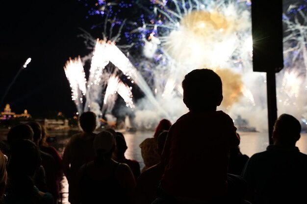 Foto silhouette von menschen, die nachts feuerwerk sehen