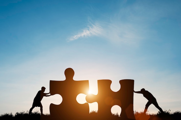 Foto silhouette zwei männer drücken, um puzzle mit sonnenlicht und blauem himmel zu verbinden.