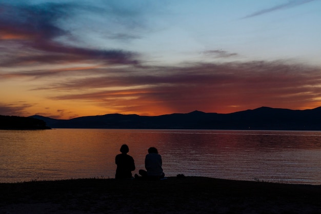 Silhouetten auf Menschen am Strand bei Sonnenuntergang