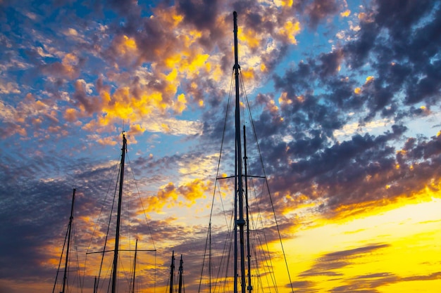 Silhouetten der Masten von Segelyachten vor einem Sonnenuntergangshintergrund