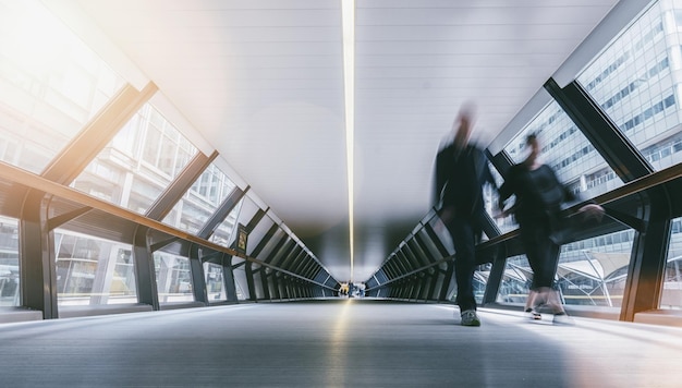 Silhouetten verschwommener Menschen in einem futuristischen Tunnel