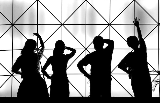 Silhouetten von Freunden, die vor gemustertem Glas stehen