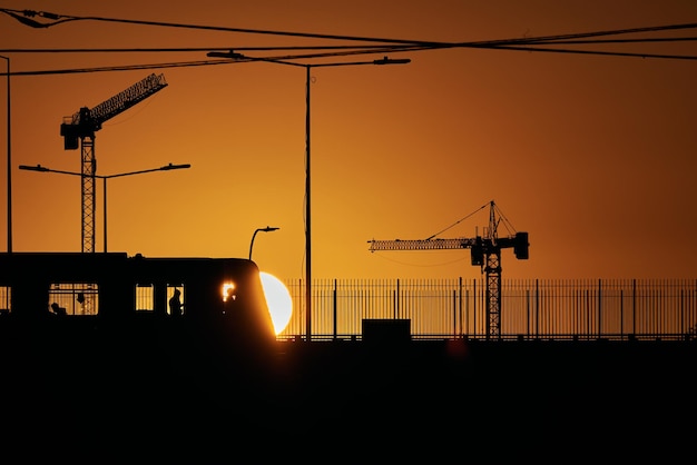 Foto silhouetten von kränen auf der baustelle gegen den himmel bei sonnenuntergang