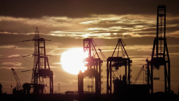 Foto silhouetten von kränen und strommasten gegen den himmel bei sonnenaufgang