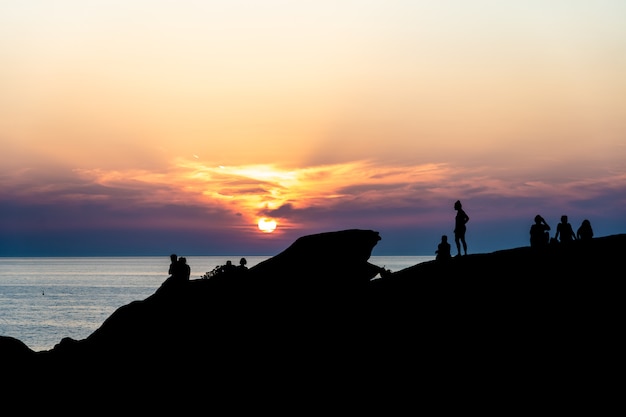 Silhouetten von Menschen bei Sonnenuntergang.