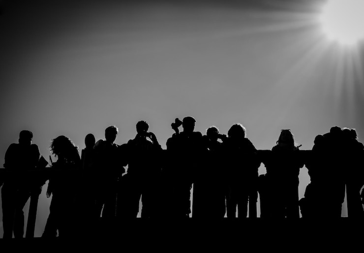 Foto silhouetten von menschen, die vor einem klaren himmel stehen