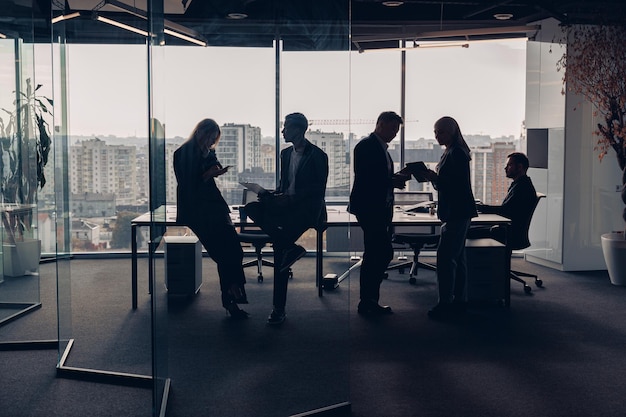 Silhouettenfoto von Geschäftsleuten während des Arbeitstages im modernen Tagungsraum