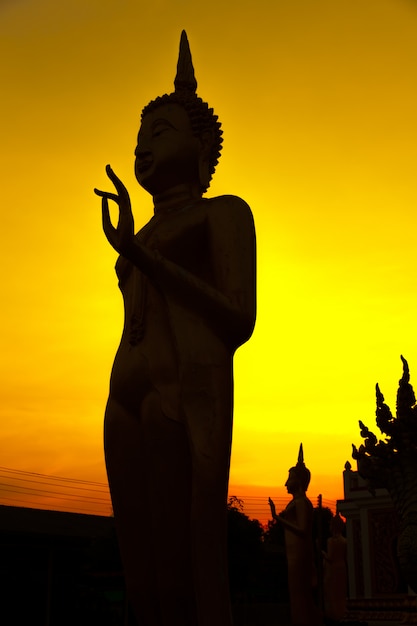 Silhouettieren Sie Bild von Buddha auf goldenem Sonnenunterganghimmel